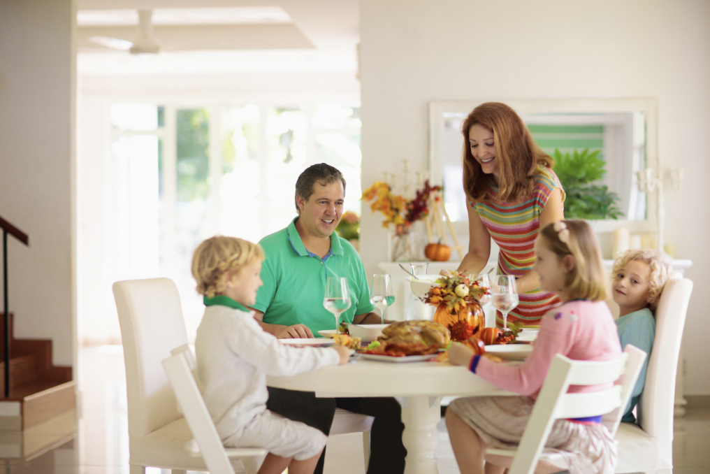 Parents and their children eating dinner together, without their phones; establishing a tech-free zone.